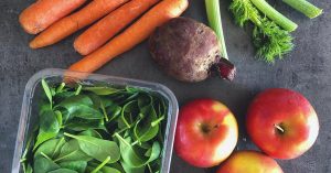 Colorful arrangement of fresh fruits and vegetables on dark background.